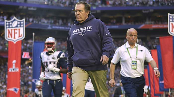 Bill Belichick walks onto the field before Super Bowl XLIX